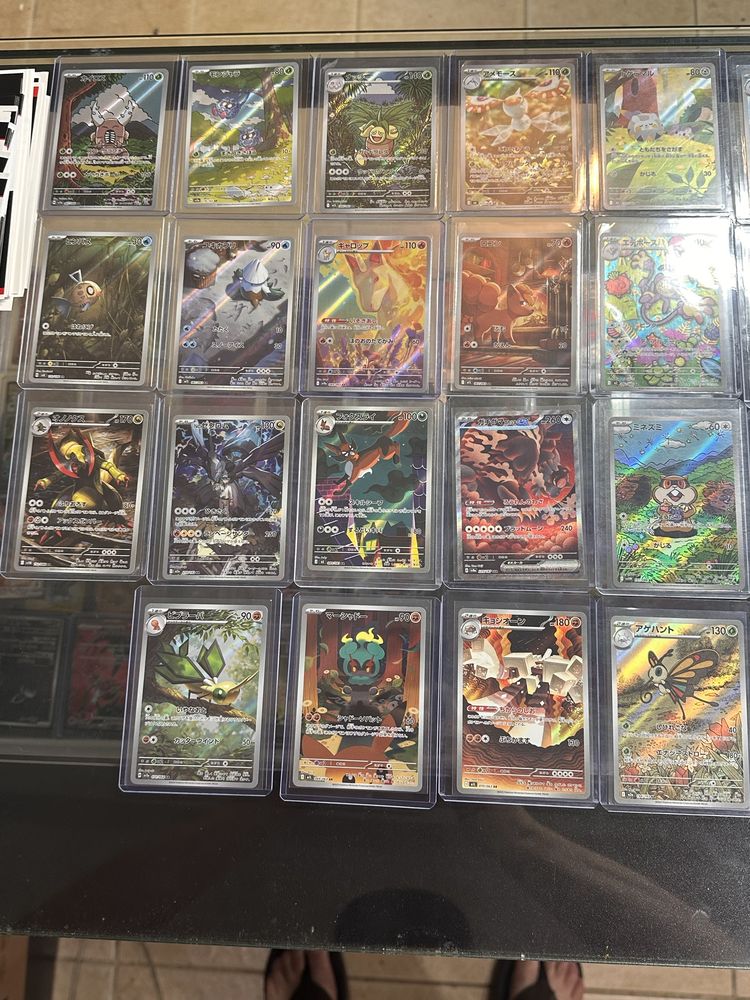 Japanese Pokémon art rare cards in top loaders on the glass counter